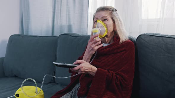 Vulnerable Old Woman in Quarantine Using Oxygen Inhaler and Changing Chanels on Tv