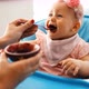 Portrait of Happy Young Baby in High Chair Being Fed By Mum - VideoHive Item for Sale