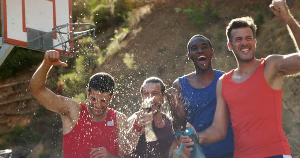 Basketball players celebrating by splashing water on each other