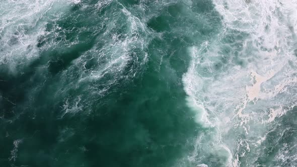 Mesmerizing shot of waves crashing on a beach view from above.