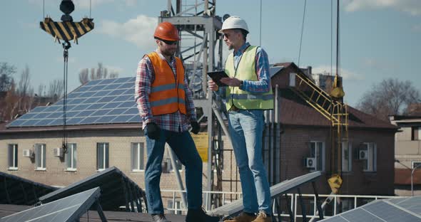 Engineer and Technician Discussing Between Solar Panels