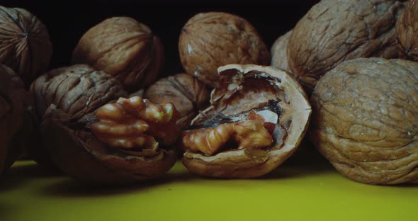 Closeup Shot of Walnuts Which Lie on a Yellow Table Against a Black Background