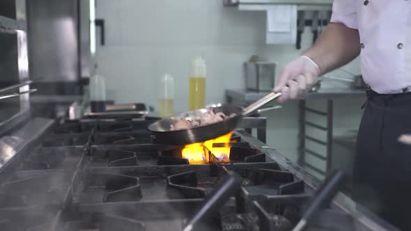 Chef Throws Up Cooking Octopuses in Frying Pan in Kitchen