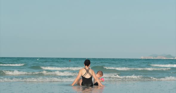 Happy and Carefree Mother and Son Play By the Sea, Sunbathe, Swim