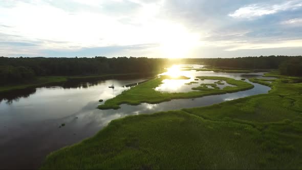 Flying backwards low near the water during sunrise over a river