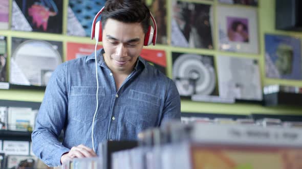 A Young Man eagerly browses through a selection of vintage records