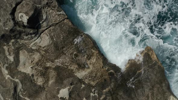 Aerial Overhead Top Down Birds Eye View of Big Waves Crashing and Splashing Water on Rocks