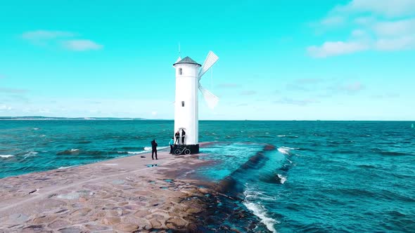 Mill in the sea. Seascape. Waves near the structure in the water.