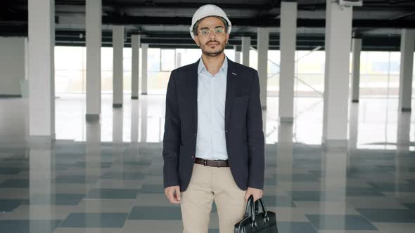 Portrait of Ambitious Construction Investor in Helmet and Suit Standing in Empty Plant