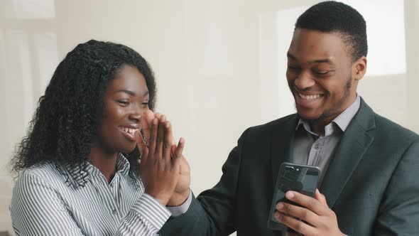 Happy Confident Smart Young Multiethnic Colleagues Looking at Cellphone Check Social Media
