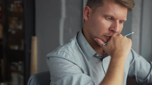 Thinking young businessman in office