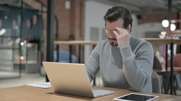 Young Man Having Headache While Working on Laptop