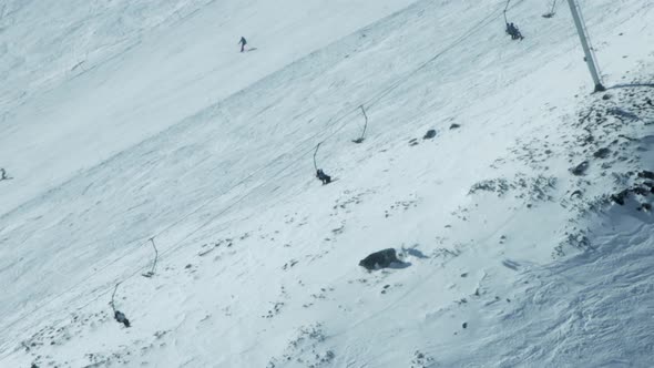 ski lifts transport skiers up an alpine snowy slope in ski resort