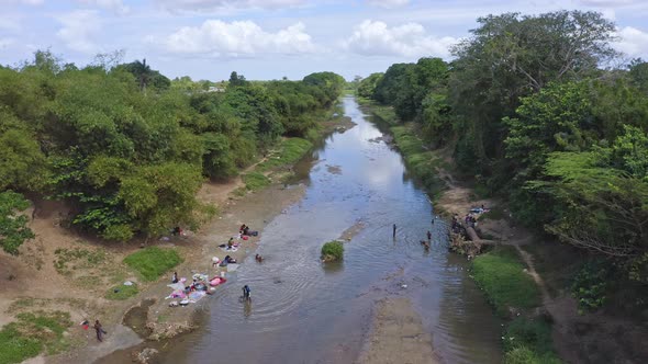 Haitian families washing their dirty clothing in the Dajabón river; drone