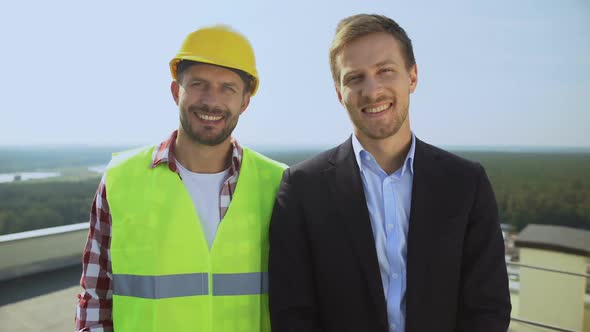 Construction Worker in Helmet and Director Smiling on Camera, Professional Team