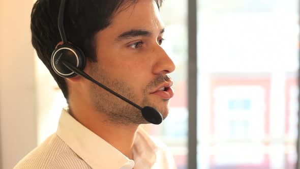 Businesss male talking on headset in office