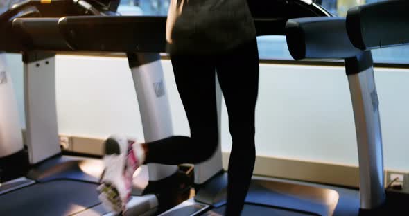 Rear view of fit woman exercising on treadmill