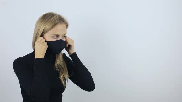 Young Woman Puts on a Protective Mask Against the Virus. Weekdays During a Pandemic, Protection