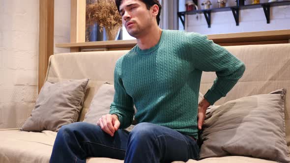 Man with Back Pain Trying to Relax on Couch at Home