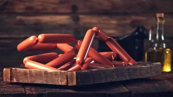 Super Slow Motion Wooden Tray with Sausages Falls on the Table