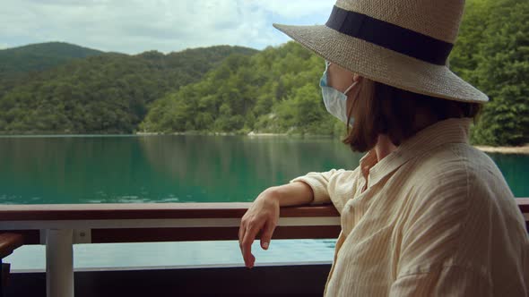 Attractive woman in medical mask on a ship