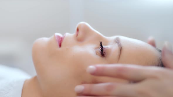 Closeup Face of Pretty Relaxing Woman Having Good Time at Beauty Massage Salon Side View