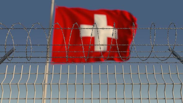 Barbed Wire Against Waving Flag of Switzerland