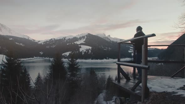 Millennial young male traveler looking out at winter landscape, arms wide open, feeling freedom. Car