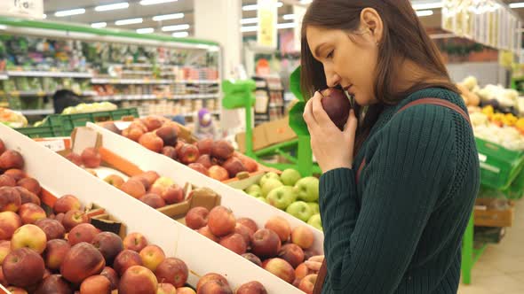 Young Woman Choosing Red Apple at Fruit Vegetable Supermarket Marketplace