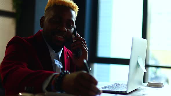 Cheerful Businessman Entrepreneur Talking Mobile Phone and Writing Note at Office