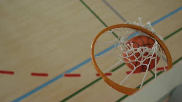 Overhead view of african american male basketball player scoring goal against diverse players