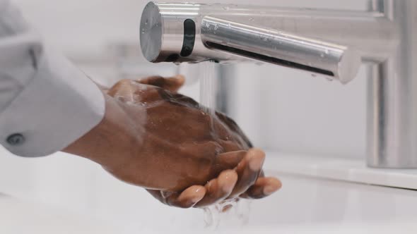 Closeup Young Unrecognizable African American Man Businessman Washes Hands in Modern Bathroom Slow