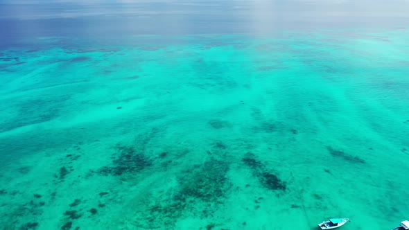 Wide angle birds eye travel shot of a white paradise beach and blue sea background 