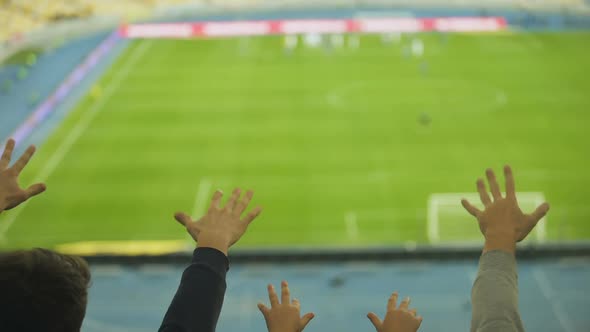 Male and Kid Fans Shaking Fingers at Stadium, Cheering for Football Team Victory