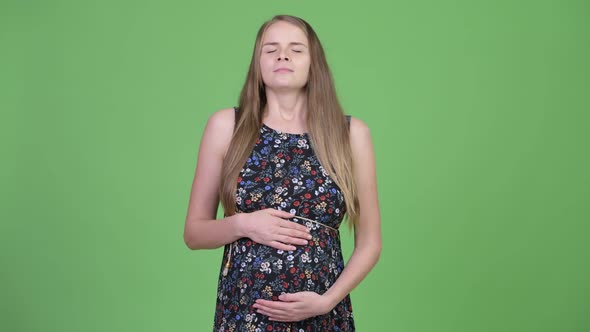 Young Happy Pregnant Woman Relaxing with Eyes Closed