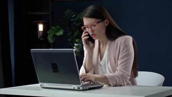 Successful Businesswoman Using Laptop Talking on Phone Making Business Call at Work Smiling Female