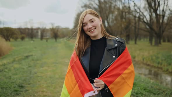 Real LGBT Lesbian Woman Smiling Covered in Rainbow Flag