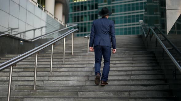 Confident Man is Going Up on Stairs to Luxury Modern Building in Fashionable District of City