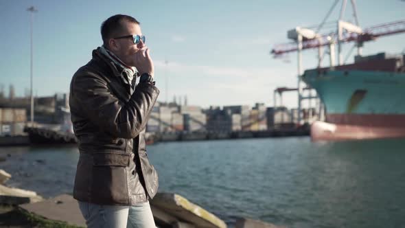 Young Attractive Guy Smoking a Cigarette in the Harbor
