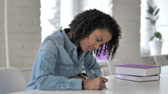 Young African Girl Writing in Office