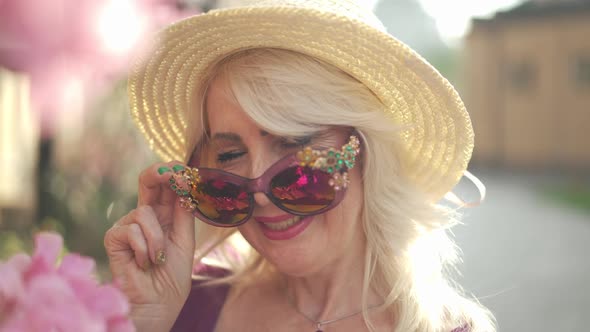 Headshot Smiling Adult Woman Winking Looking at Camera Putting on Sunglasses