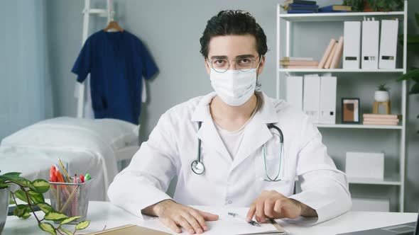 Doctor Working at Hospital Closeup Young Surgeon Sitting at Workplace Male Therapist Wearing Medical