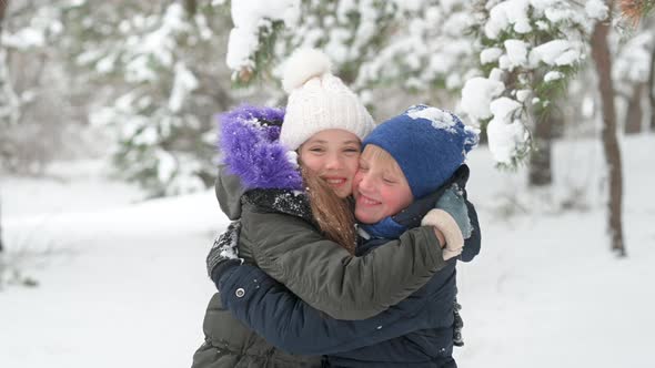 Happy children in warm clothes play in a snowy park