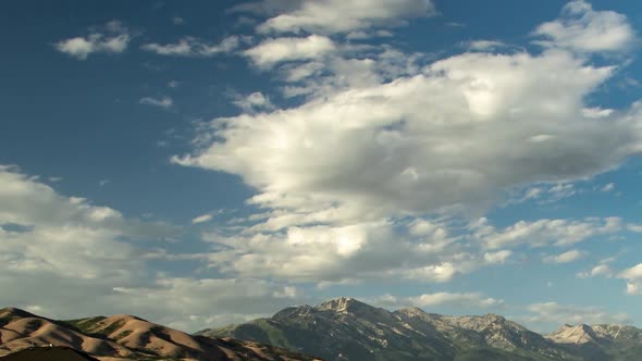 Panoramic time lapse of a rugged mountain range with a dramaticly beautiful cloudscape above