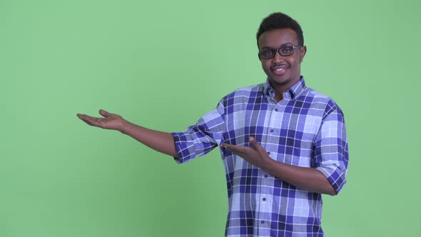 Happy Young African Hipster Man Showing Something