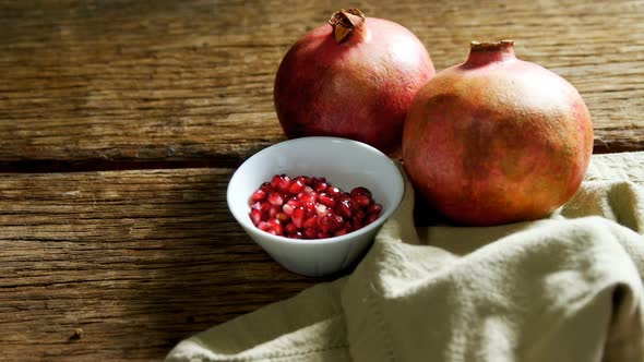 Pomegranate and napkin on wooden table 4k