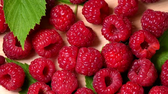 Ripe raspberry rotating top view on wooden background