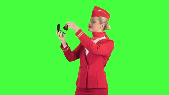 Stewardess Looks in the Mirror and Paints Her Face with a Tassel. Green Screen