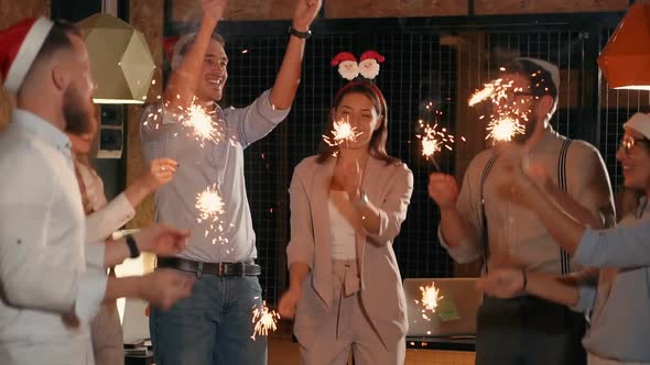 Office Employees Are Celebrating Christmas in Working Place Burning Sparkles