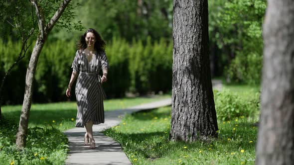 Happy Adult Woman is Walking Alone in Park at Sunny Morning Strolling Barefoot Over Path